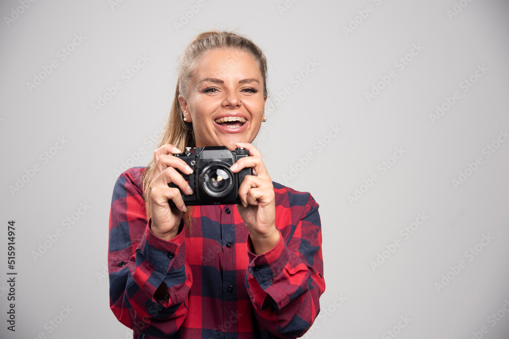 Blonde photograph in checked shirt taking photos and feels positive