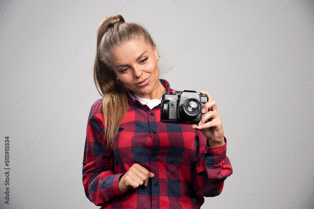 Blonde model in checked shirt looks positive and glamour while taking photos Blonde model in checked shirt looks positive and glamour while taking photos