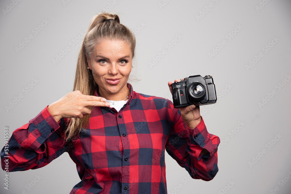 Blonde model in checked shirt points her camera Blonde model in checked shirt points her camera