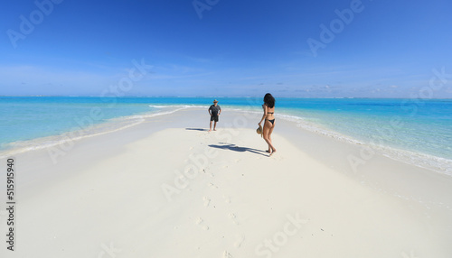 man and girl on white sand beach on tropical island