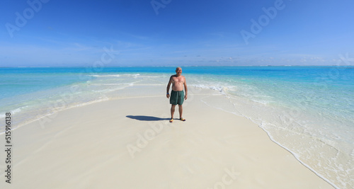 one man on a tropical island with white sand in the ocean