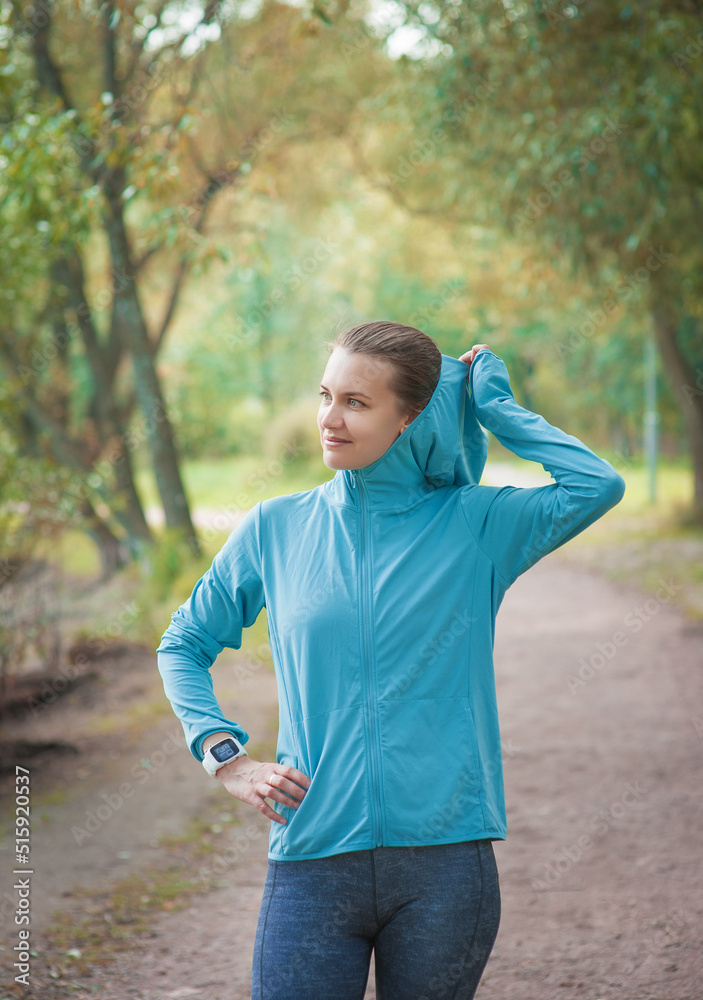 Beautiful fitness woman runner in the blue hoodie