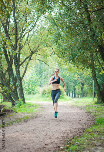 Active beautiful woman running in the park outdoor