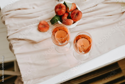 Dessert peaches and glass of wine on minimal white background 