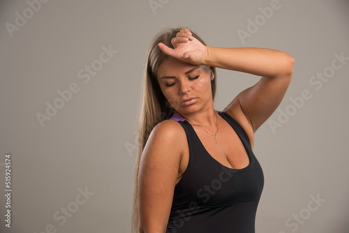 Female model in sport bra holds her head