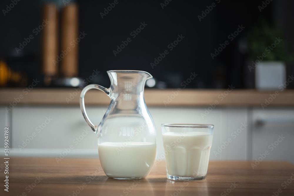 Happy little caucasian girl drinking milk in the stylish kitchen. Health benefits of milk for little kids concept Happy little caucasian girl drinking milk in the stylish kitchen. Health benefits of milk for little kids concept