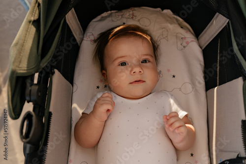 Obraz na płótnie close up portrait of lovely cute little boy in baby carriage posing at camera. Portrait of smiling happy beautiful little kid outdoors on summer day w salonie