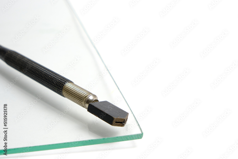 Piece of glass and manual glass cutter white background.