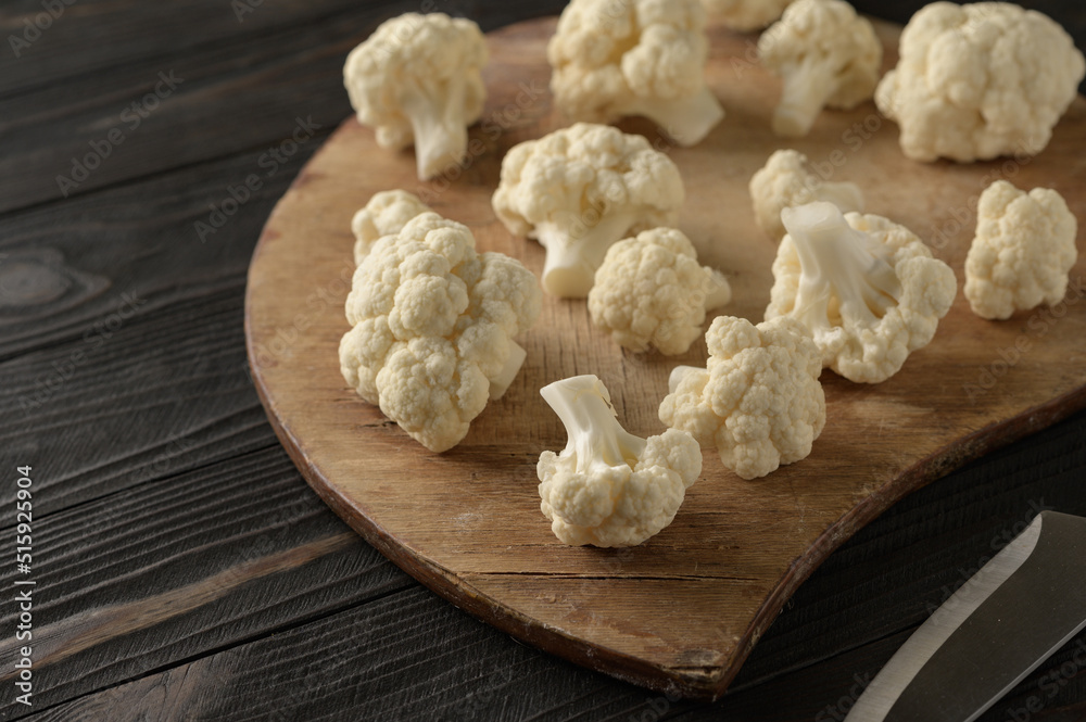 Raw, fresh organic cauliflower on a wooden background. Healthy eating, low carb diet concept Raw, fresh organic cauliflower on a wooden background. Healthy eating, low carb diet concept