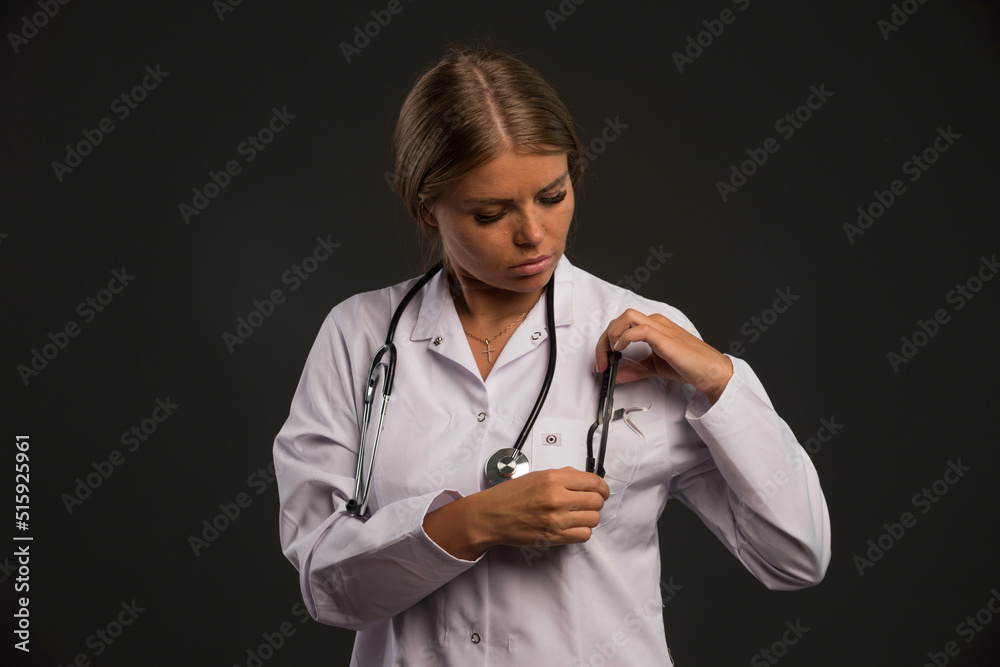 Blonde female doctor with a stethoscope looking down Blonde female doctor with a stethoscope looking down