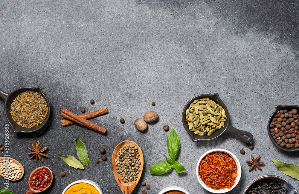 Assortment of aromatic herbs and spices on grey rustic background with copy space for your design top view.