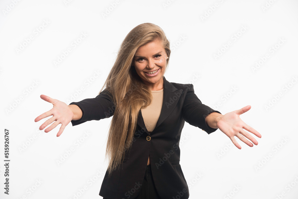 Young businesswoman in black suit makes presentation with hand gests Young businesswoman in black suit makes presentation with hand gests