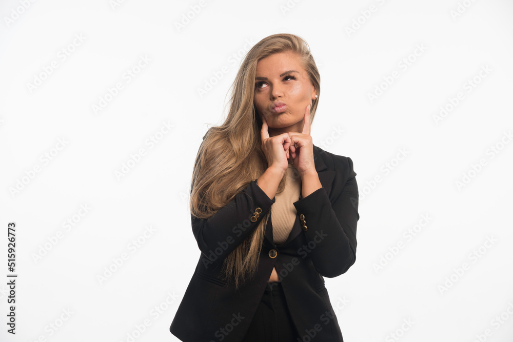 Young businesswoman in black suit looks thoughtful Young businesswoman in black suit looks thoughtful