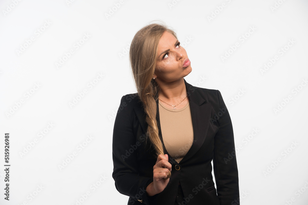 Young businesswoman in black suit playing with her hair Young businesswoman in black suit playing with her hair