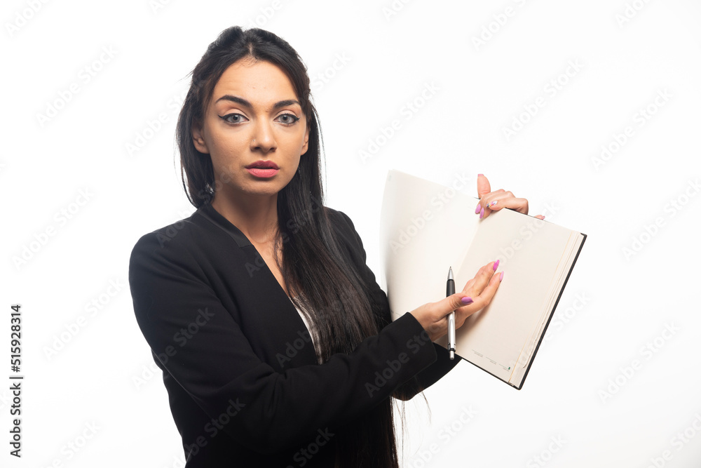 Business woman holding a notebook with pencil on white background Business woman holding a notebook with pencil on white background