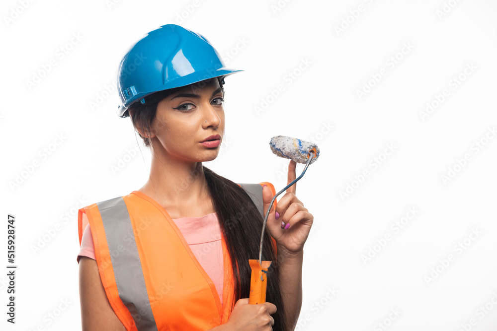 Female painter or builder with paint roller over white background Female painter or builder with paint roller over white background