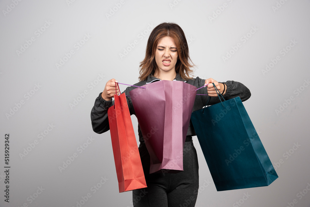 Photo of young woman holding shopping bags