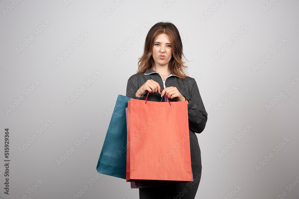 Photo of young woman holding shopping bags Photo of young woman holding shopping bags