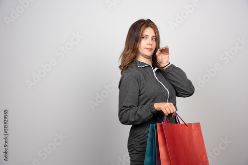 Photo of young woman holding shopping bags