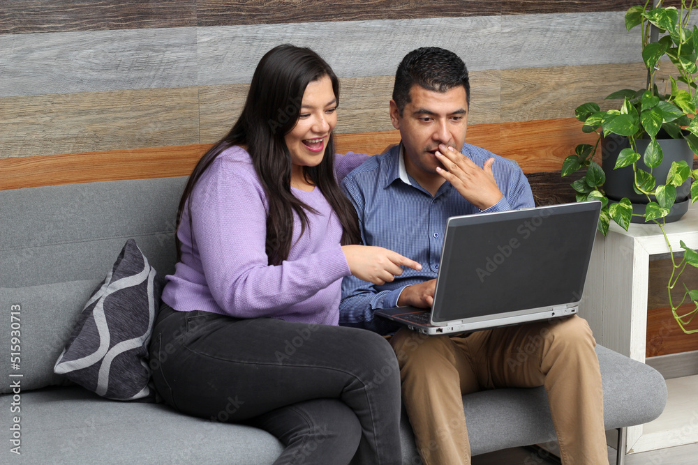 Latino adult man and woman couple use their laptop in the living room to shop online, make payments, plan trips, view photos and make video calls
Latino adult man and woman couple use their laptop in the living room to shop online, make payments, plan trips, view photos and make video calls
