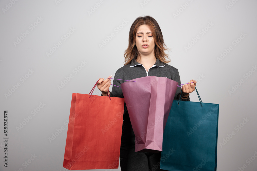 Photo of young woman holding shopping bags Photo of young woman holding shopping bags