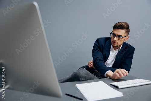handsome businessman wearing glasses works in front of a computer isolated background