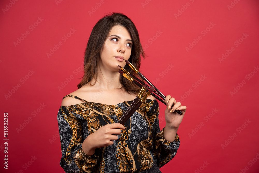 Artist girl looks at her set of new brand brushes and thinking about new projects