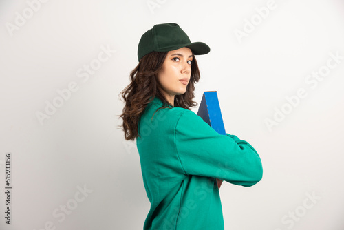 Courier in green uniform holding pizza box tightly