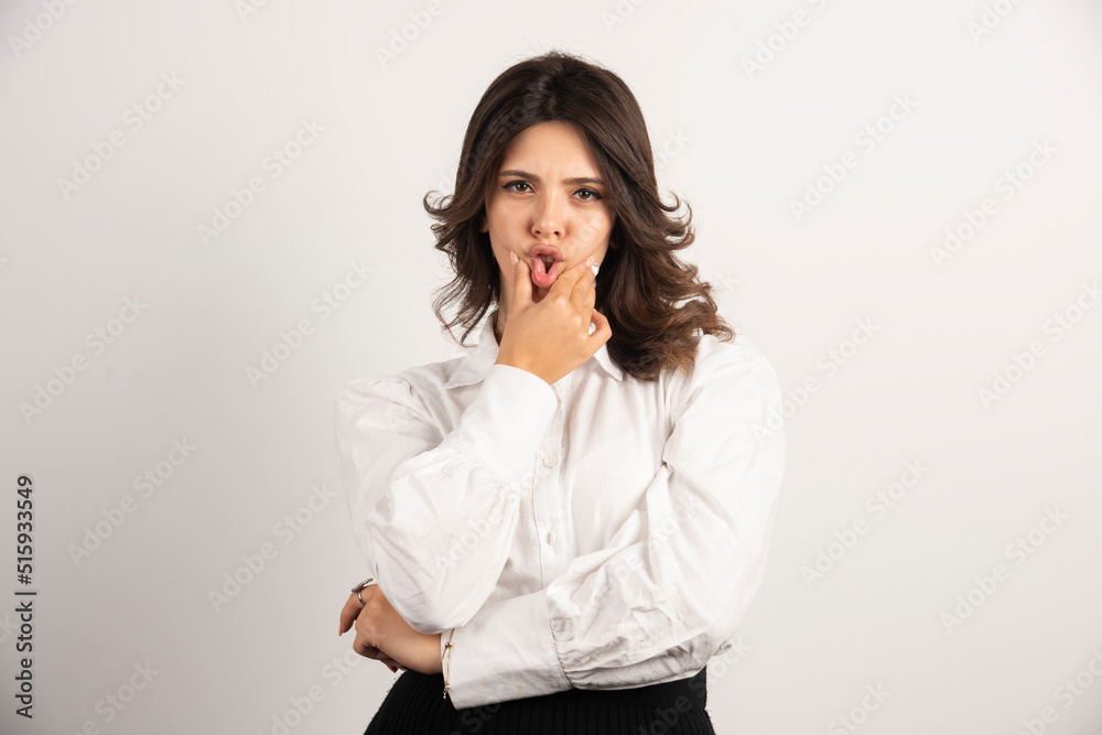 Young employee holding her mouth on white background Young employee holding her mouth on white background