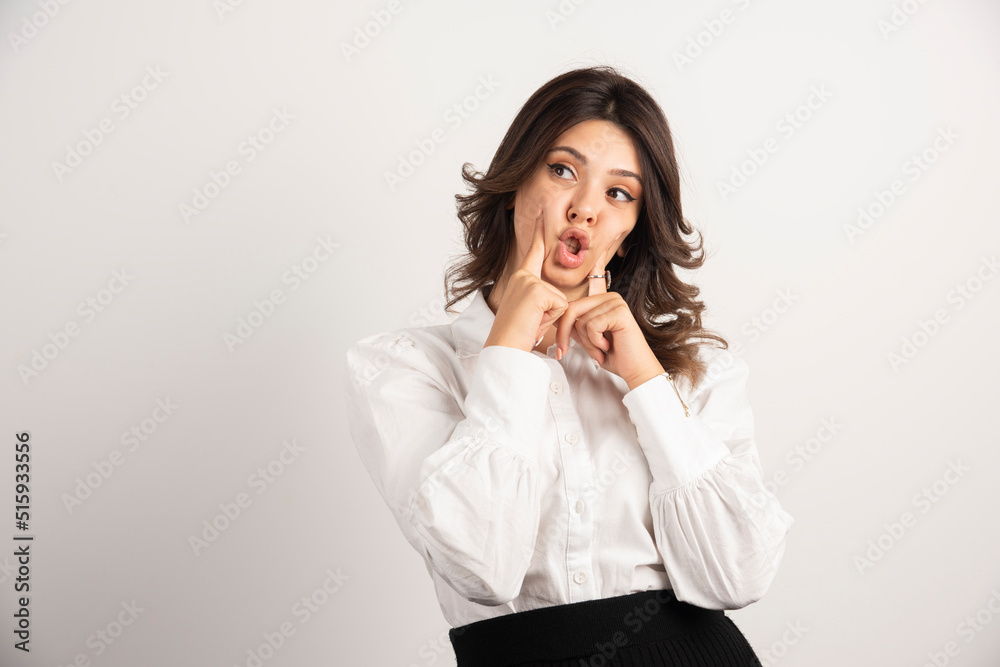 Young employee holding her mouth on white background Young employee holding her mouth on white background