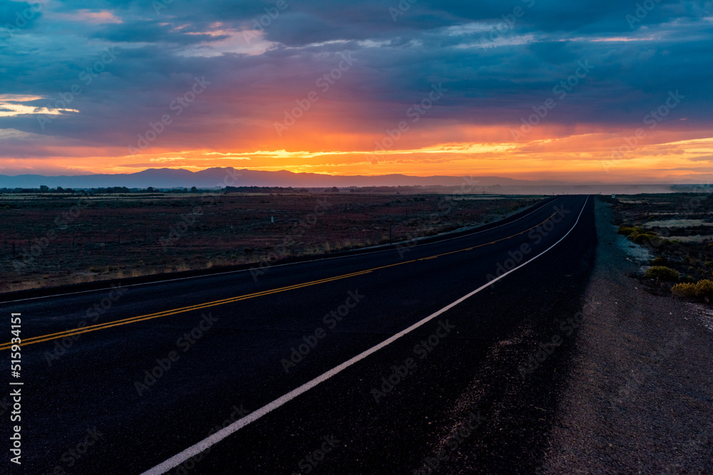 The sun setting on a long road through Idaho.