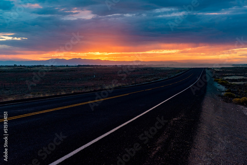The sun setting on a long road through Idaho.