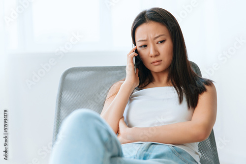 Confused upset tanned lovely young Asian woman listen shocked news at call using phone at home interior living room. Distance communication Social media concept. Cool offer Banner Wide angle Free Download Confused upset tanned lovely young Asian woman listen shocked news at call using phone at home interior living room. Distance communication Social media concept. Cool offer Banner Wide angle - GFXLoad