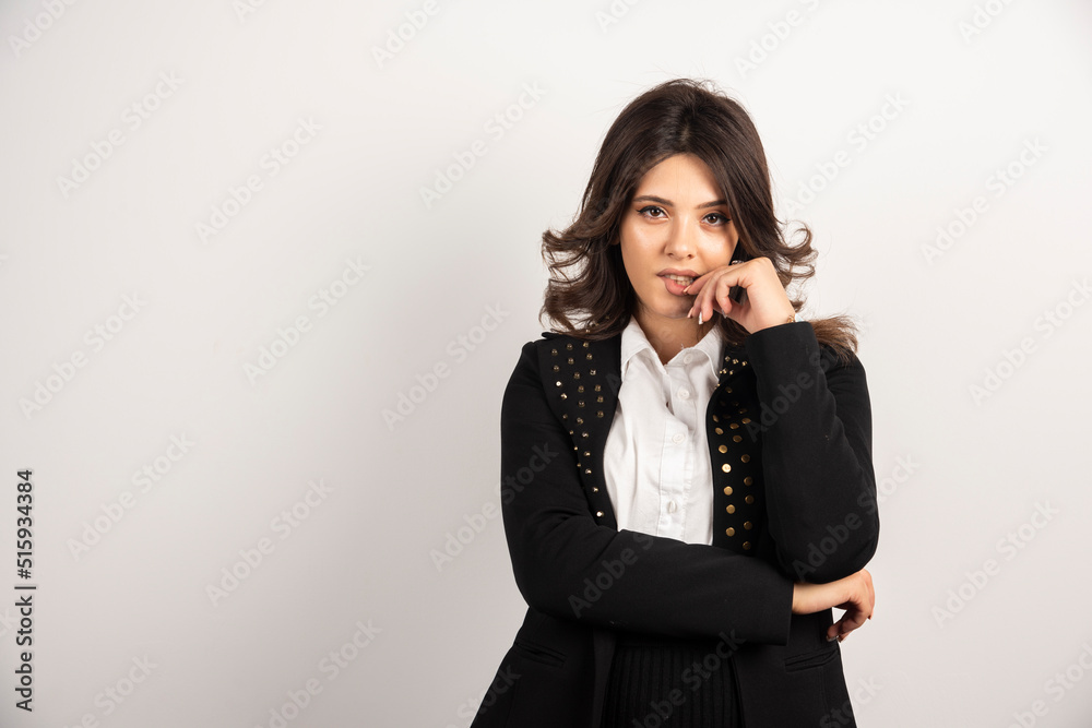 Confident woman in black jacket standing on white background Confident woman in black jacket standing on white background