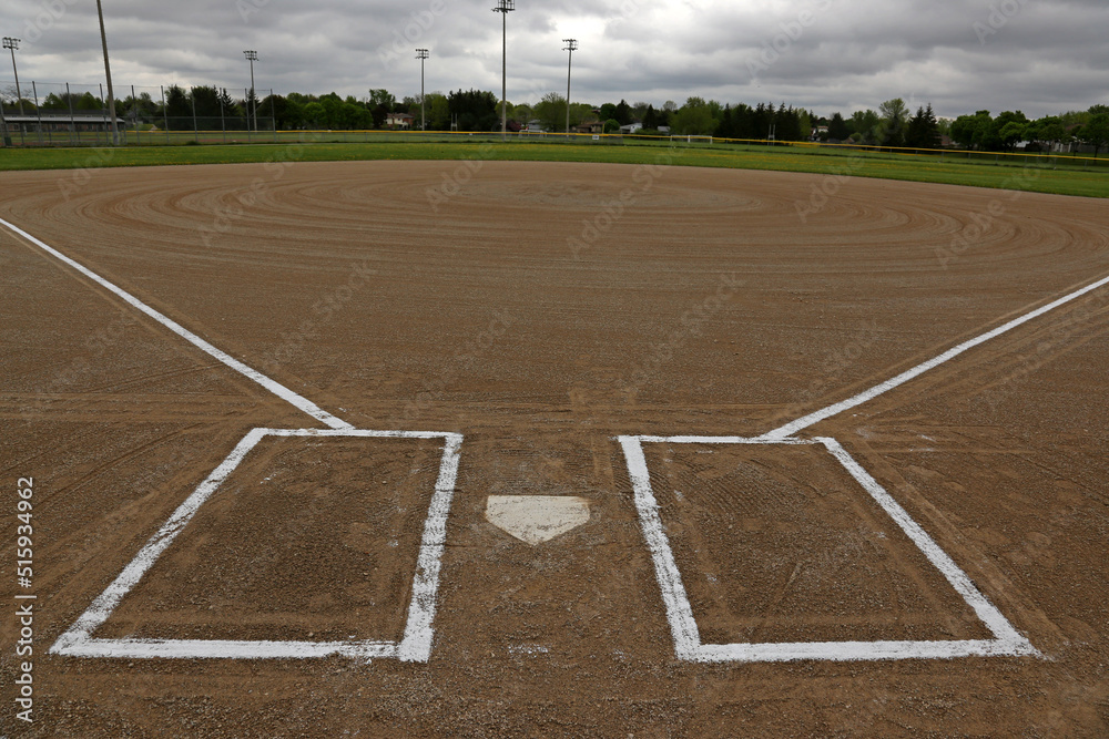 A wide angle shot of an unoccupied baseball field on a cloudy day.
