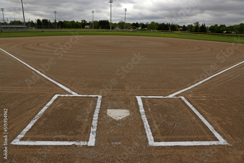 A wide angle shot of an unoccupied baseball field on a cloudy day.