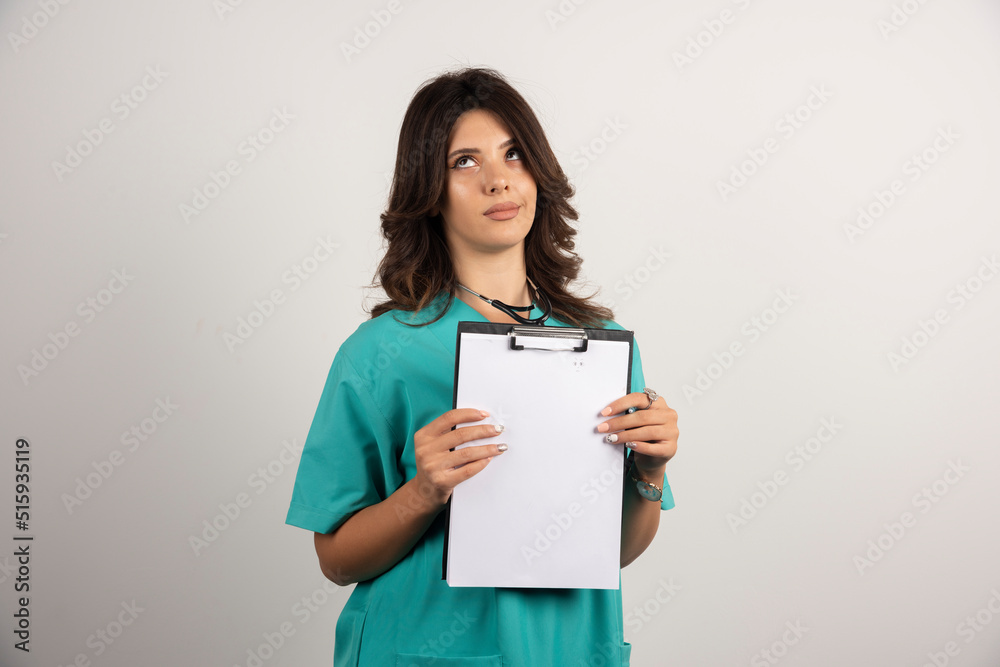 Female doctor posing with clipboard on white background Female doctor posing with clipboard on white background