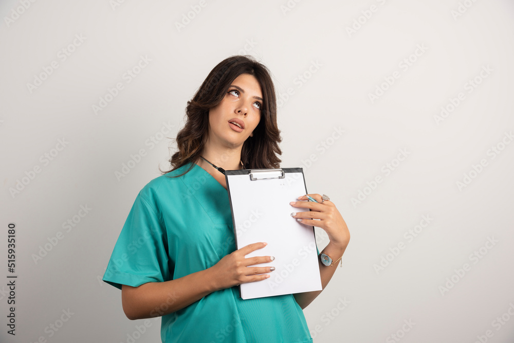 Tired doctor posing with clipboard on white background Tired doctor posing with clipboard on white background