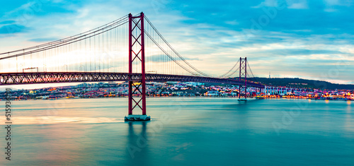 Fototapeta Naklejka Na Ścianę i Meble -  Paisaje de Lisboa al atardecer. Fotografía panorámica del puente 25 de Abril de la ciudad de Lisboa sobre el río Tajo.