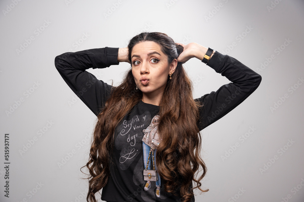 Portrait of young girl making playful face on gray background Portrait of young girl making playful face on gray background