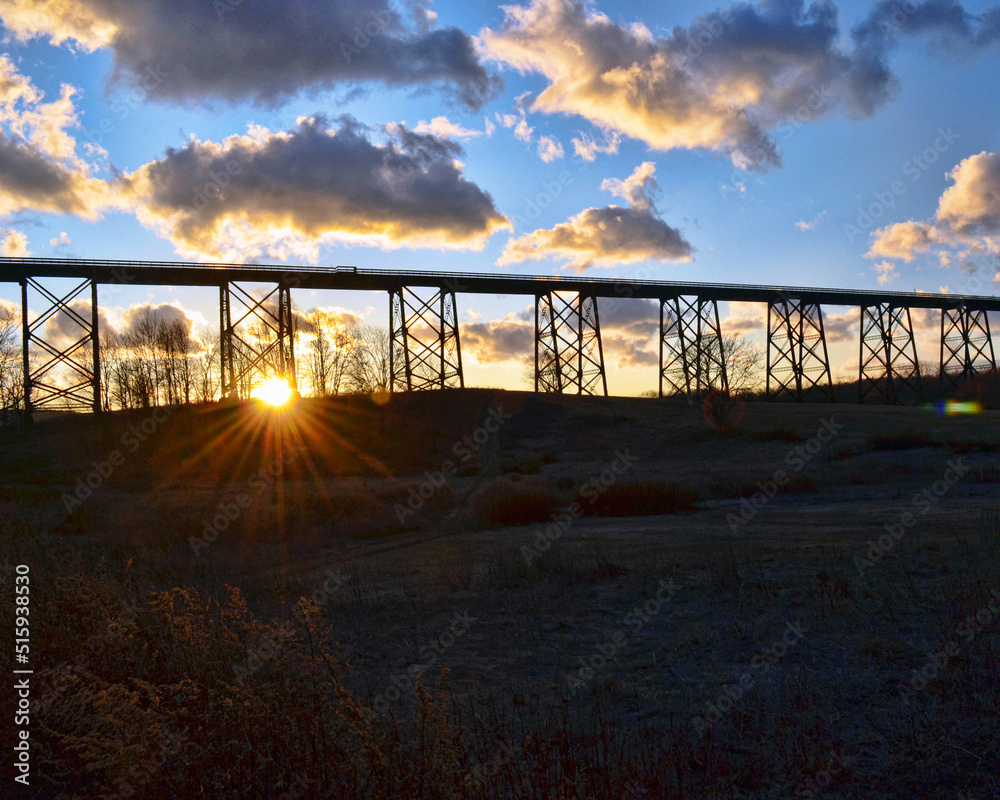 sunset behind a train bridge