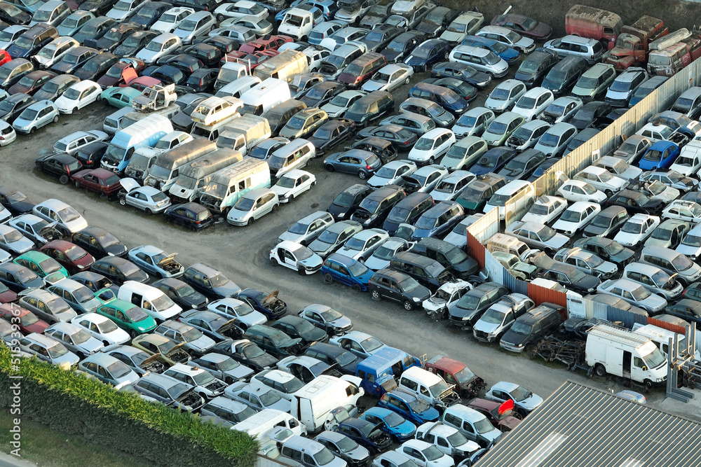 Aerial view of big parking lot of junkyard with rows of discarded broken cars. Recycling of old vehicles