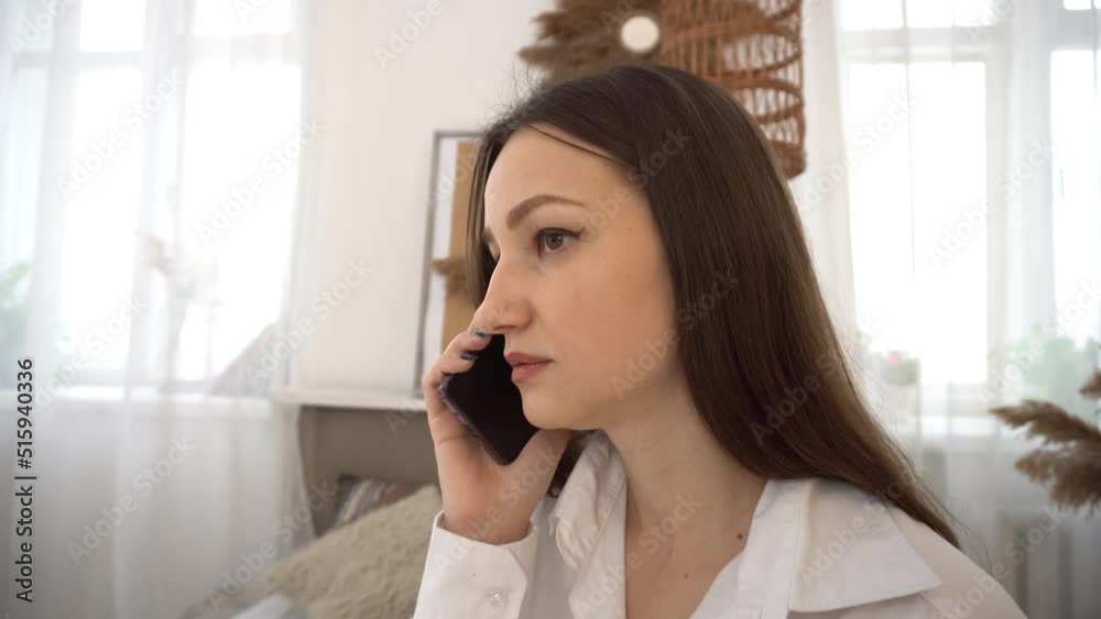 4k smiling woman talking on her smartphone in her bedroom. 4k smiling woman talking on her smartphone in her bedroom.