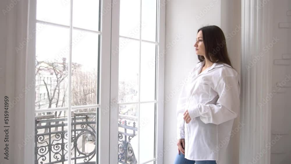 Slow Motion woman looking out window at home Slow Motion woman looking out window at home