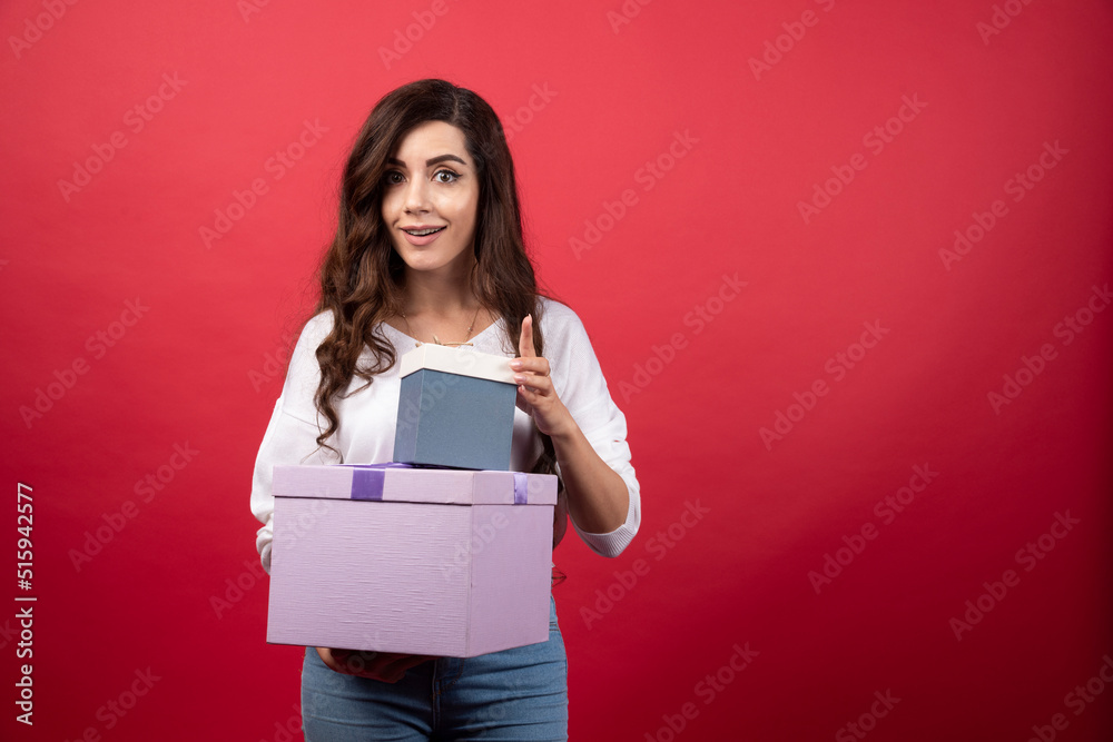 Beautiful woman holding purple and blue present boxes Beautiful woman holding purple and blue present boxes