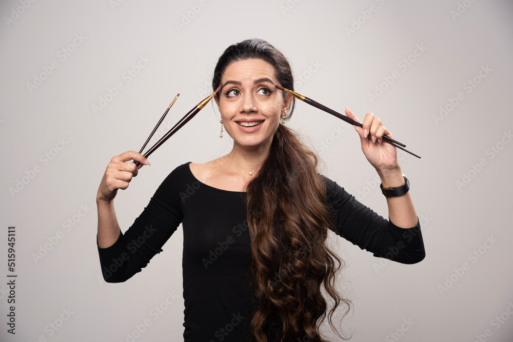 Young artist girl gives positive poses with her painting brush Young artist girl gives positive poses with her painting brush