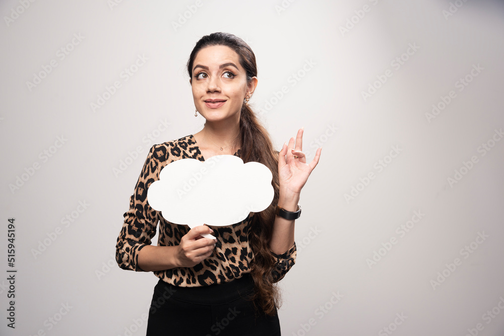 Girl in leopard printed shirt holding a cloud shape thinkboard Girl in leopard printed shirt holding a cloud shape thinkboard