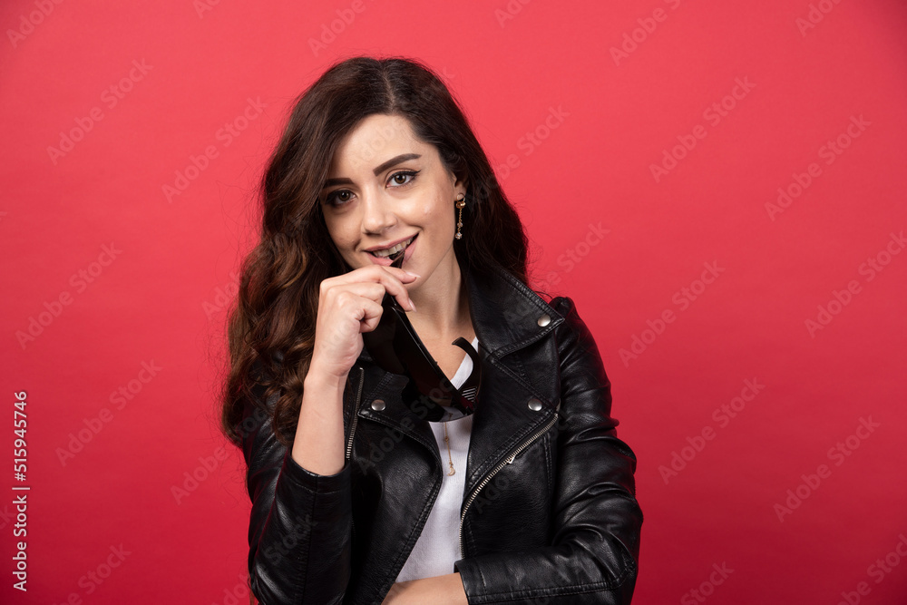 Young woman posing with black glasses on a red background Young woman posing with black glasses on a red background