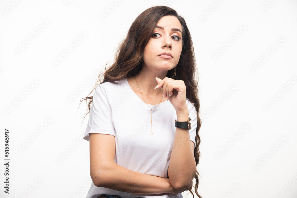 Long haired woman in white shirt standing on white background Long haired woman in white shirt standing on white background