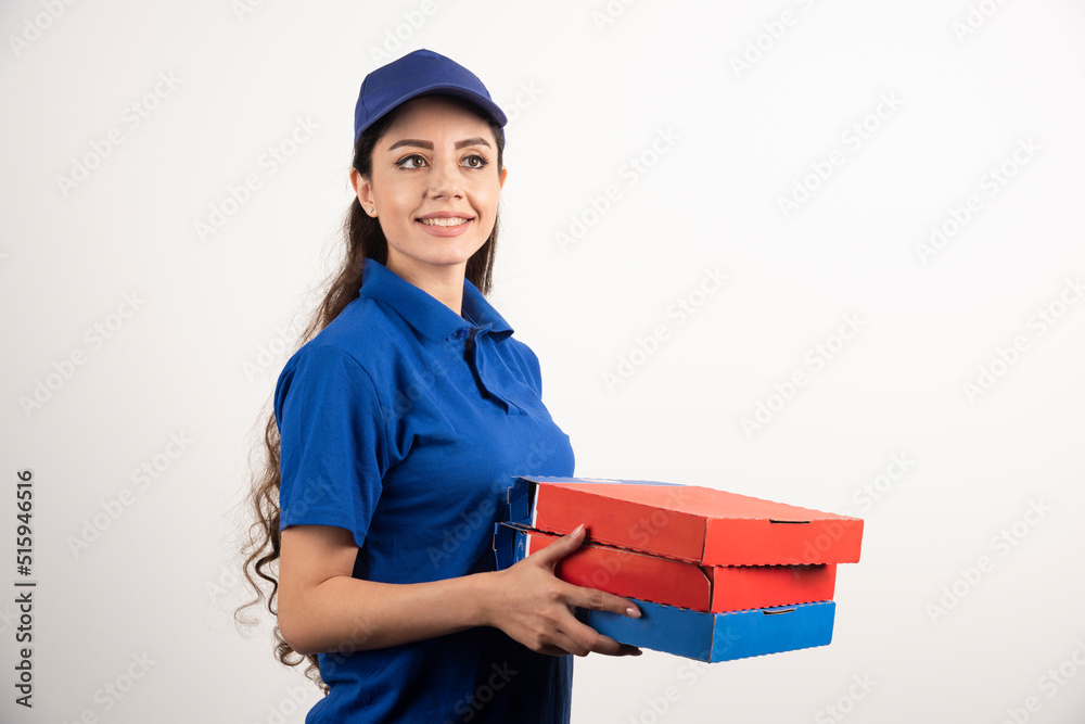 Portrait of young woman in uniform smiling and delivering pizza Portrait of young woman in uniform smiling and delivering pizza